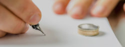 Closeup of male hand signing divorce papers - absolute divorce